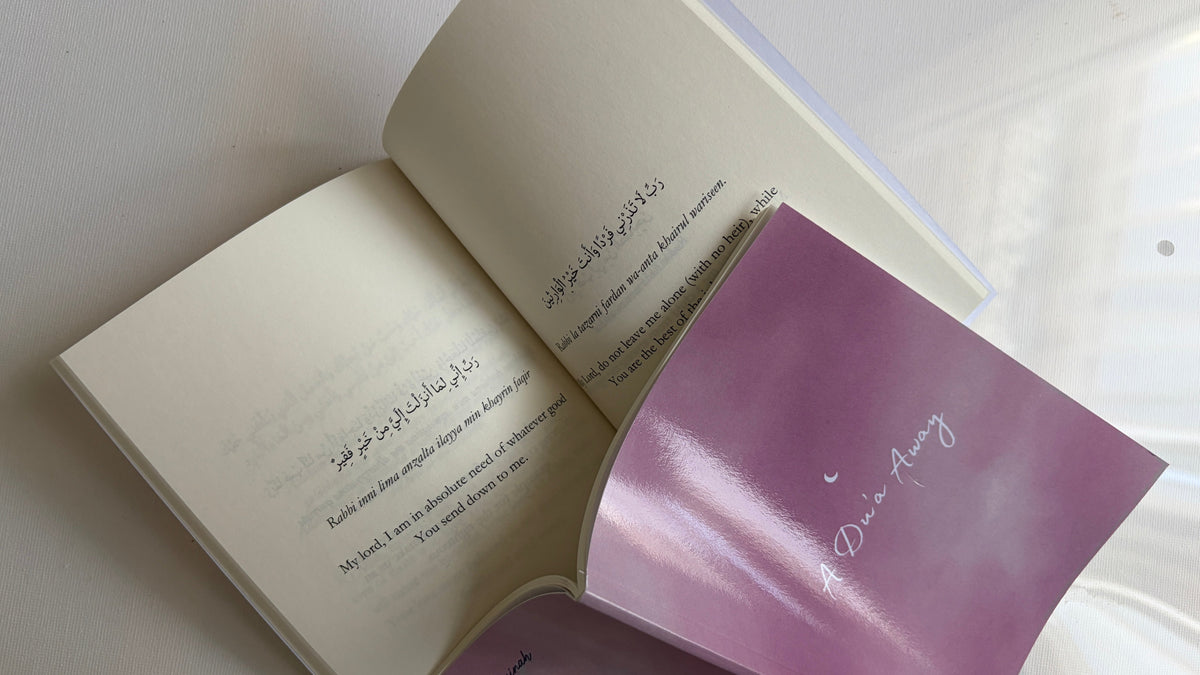 An open book with cream-colored pages printed with English and Arabic text, featuring a glossy lavender-purple insert card with the words 'Don't Worry' in white script.